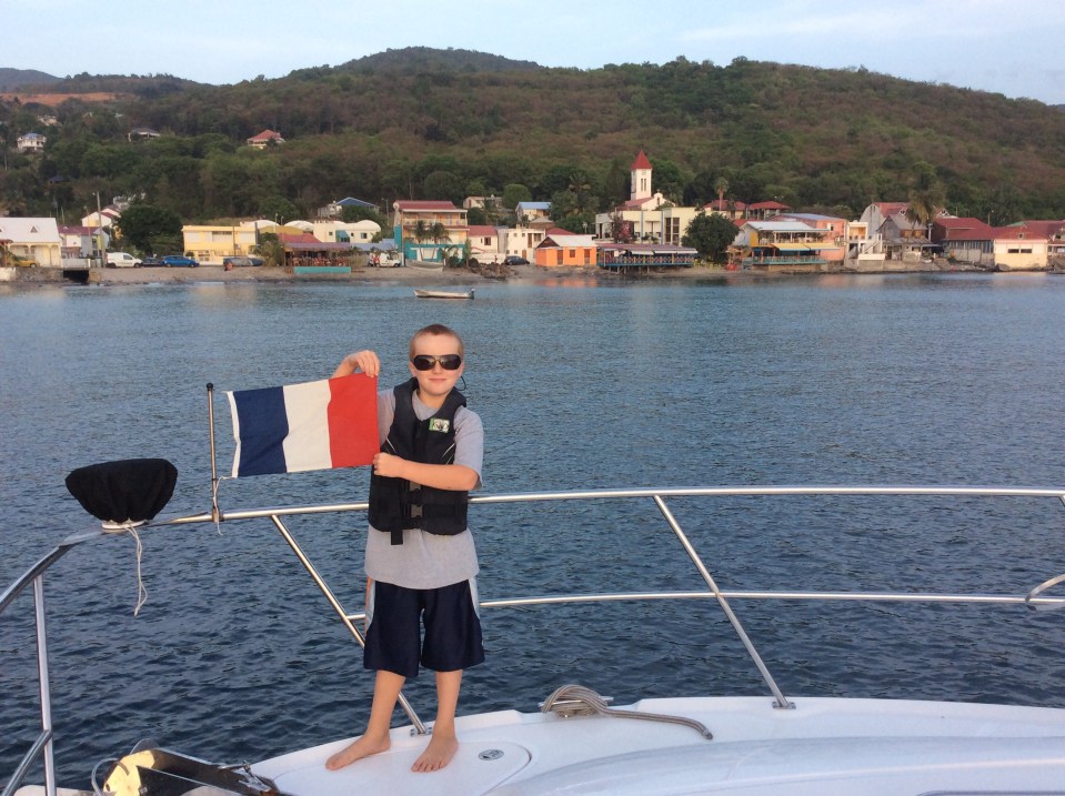 Ronan hoisting the courtesy flag, Deshaies, Guadeloupe
