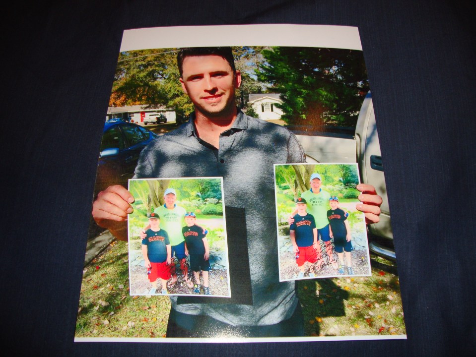Buster Posey holding pictures of the boys