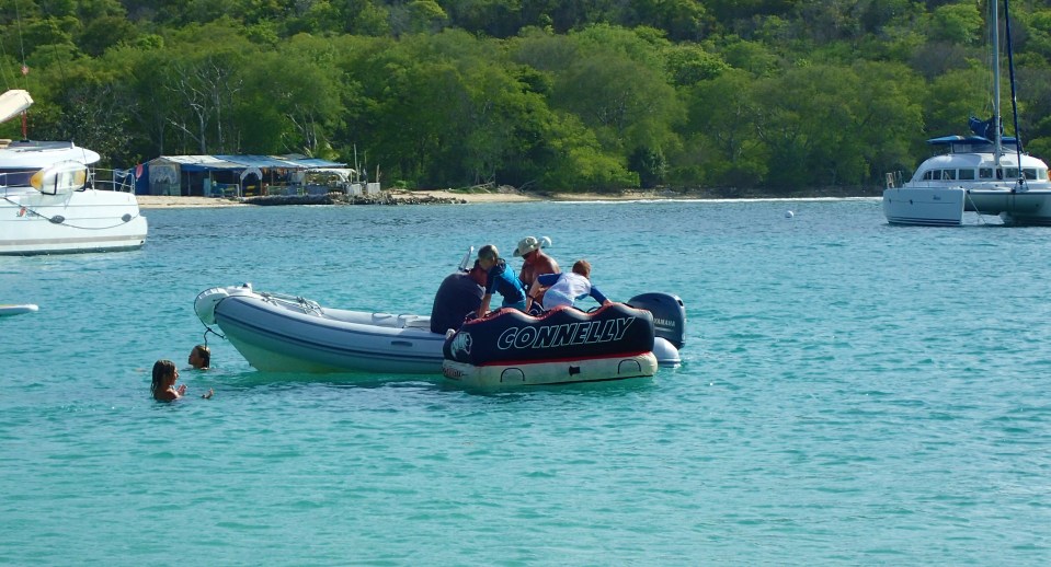 The kids getting pulled behind the dinghy, Salt Whistle Bay, Mayreau
