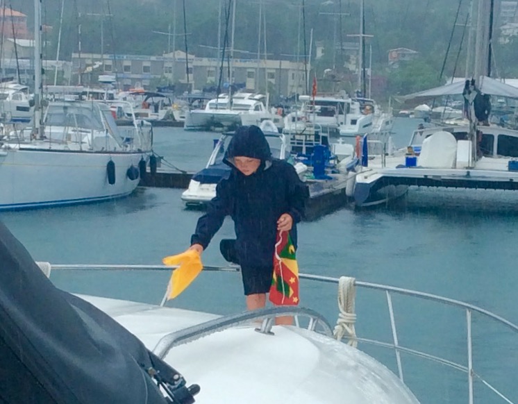 Ryan taking down the quarantine flag and hoisting the courtesy flag, Grenada
