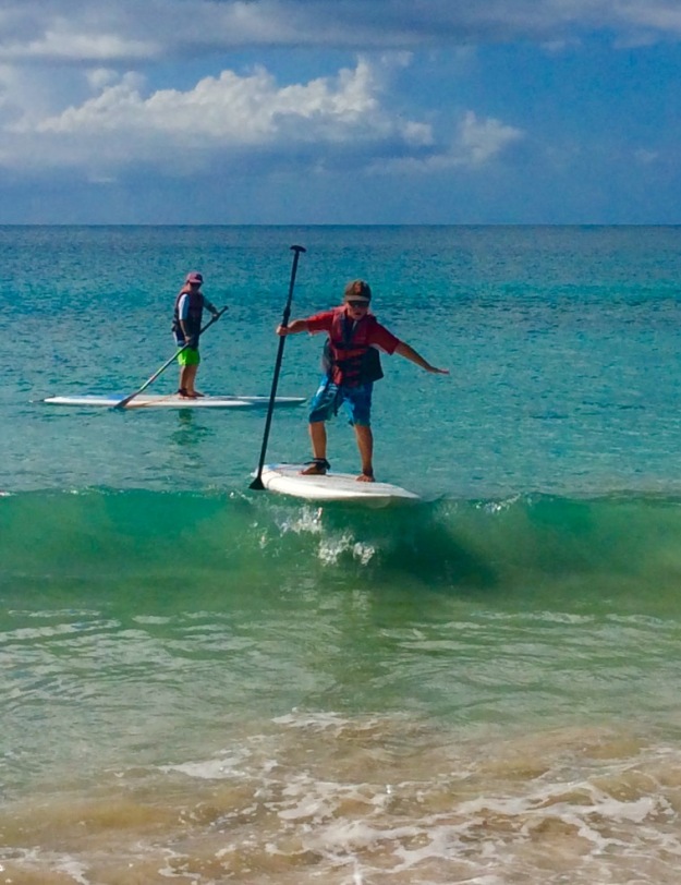 Ronan catching a wave on his stand up paddle board, Grand Anse Beach, Grenada